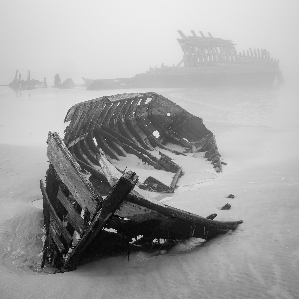 Barque épave au cimetière de bateaux du Magouër à Plouhinec, dans la brume