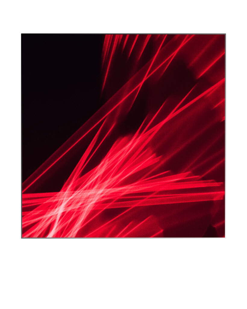 Image abstraite représentant des faisceaux lumineux rouges dynamiques et entrecroisés sur un fond noir, créant un effet visuel énergique et futuriste avec des lignes diagonales et des reflets lumineux.